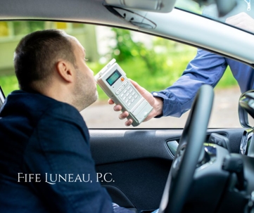 man breathes into breathalyzer