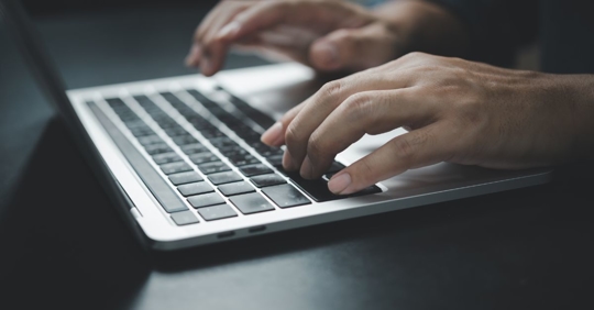 man typing on computer