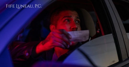 man handing documents to cop from window