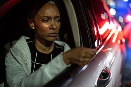 An African American woman being pulled over by the police at night.